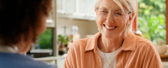 A team member engaging with an older adult in a residential memory care in Sparks, NV discussing about the benefits of memory care.