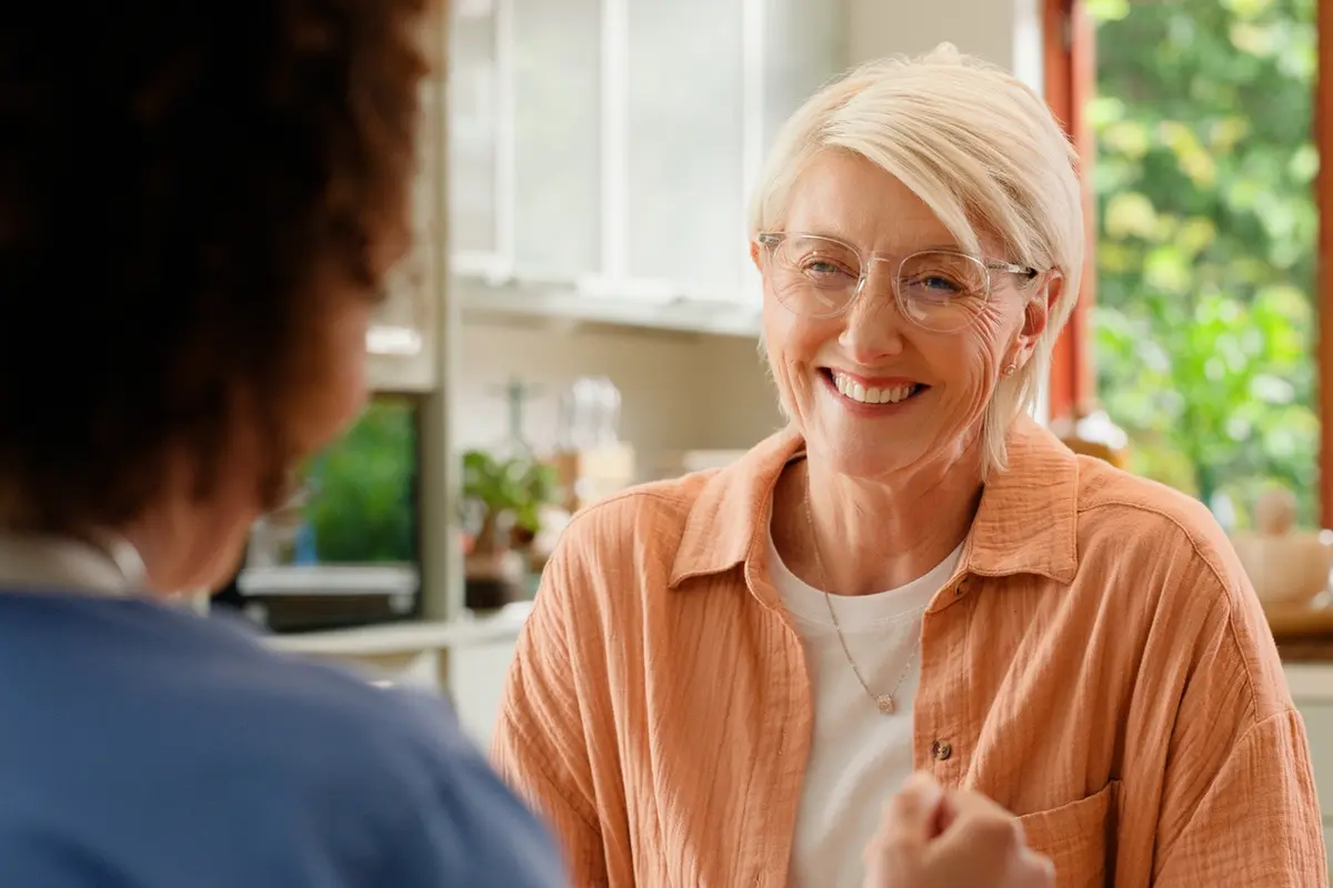 A team member engaging with an older adult in a residential memory care in Sparks, NV discussing about the benefits of memory care.