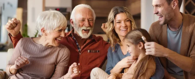 Cheerful extended family spending time together in a living room while discussing how to pay for memory care.